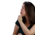young girl with finger in mouth in profile asking for silence